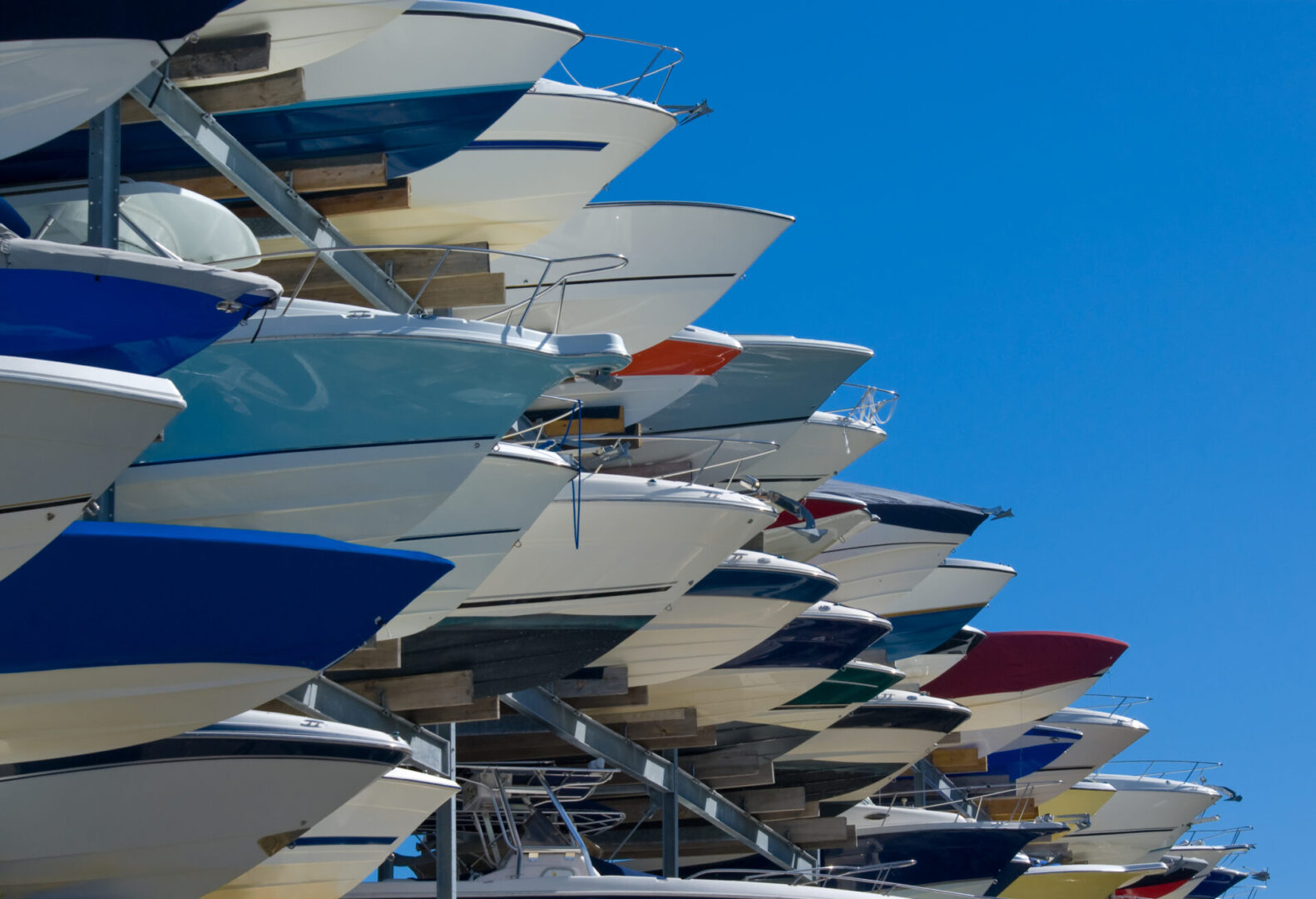 Boats stacked on a rack, sunny day.