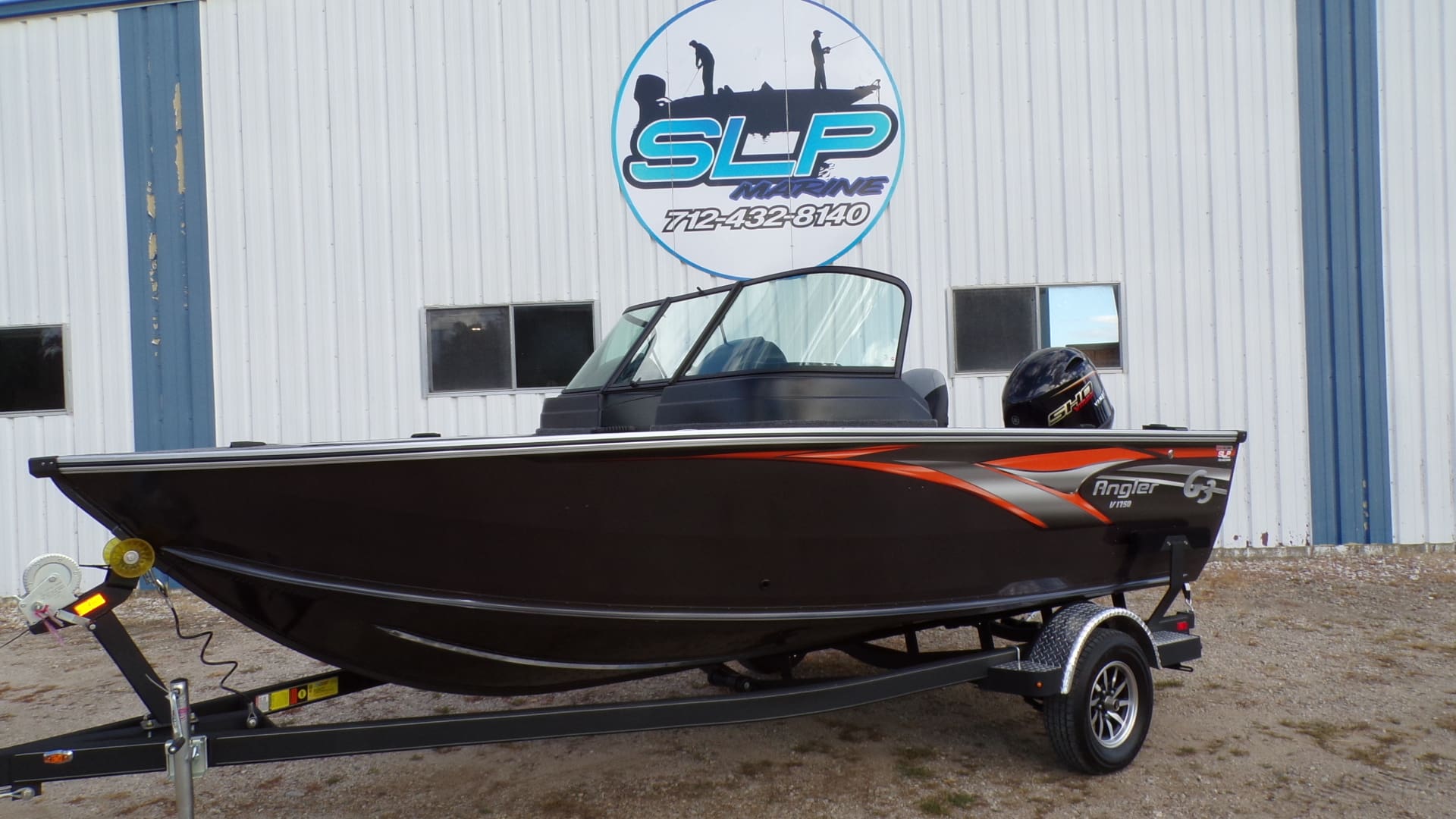 A boat parked in front of a building with a man standing next to it.