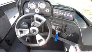 A boat 's dashboard and steering wheel are shown.