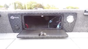 A black truck bed with a cell phone in the back.