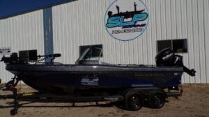 A boat parked in front of a building with a sign on it.