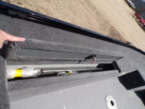 A close up of the side of a boat with a yellow handle.