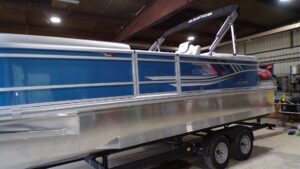 Blue pontoon boat on trailer in warehouse