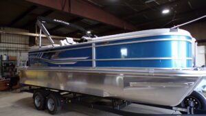 Blue pontoon boat on trailer in warehouse