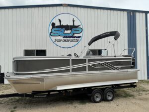 Gray pontoon boat displayed at marine shop.