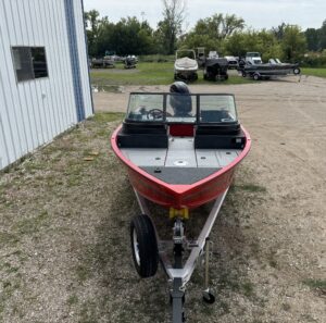 Red fishing boat parked at a marina.