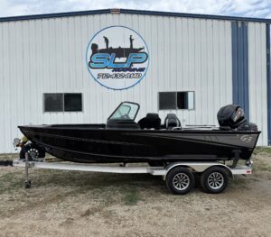 Black G3 boat on trailer at marine shop.