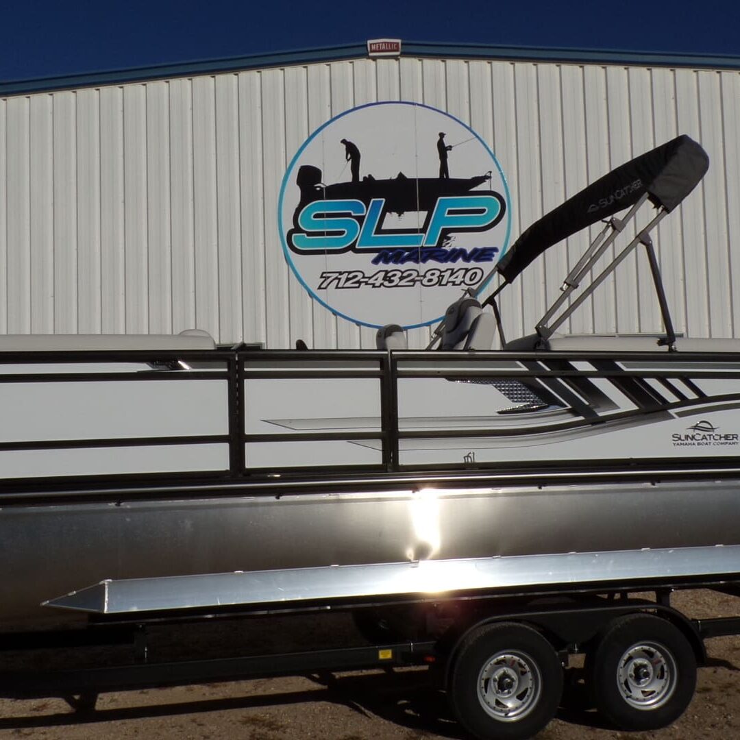 A boat parked in front of a building with a sign on it.