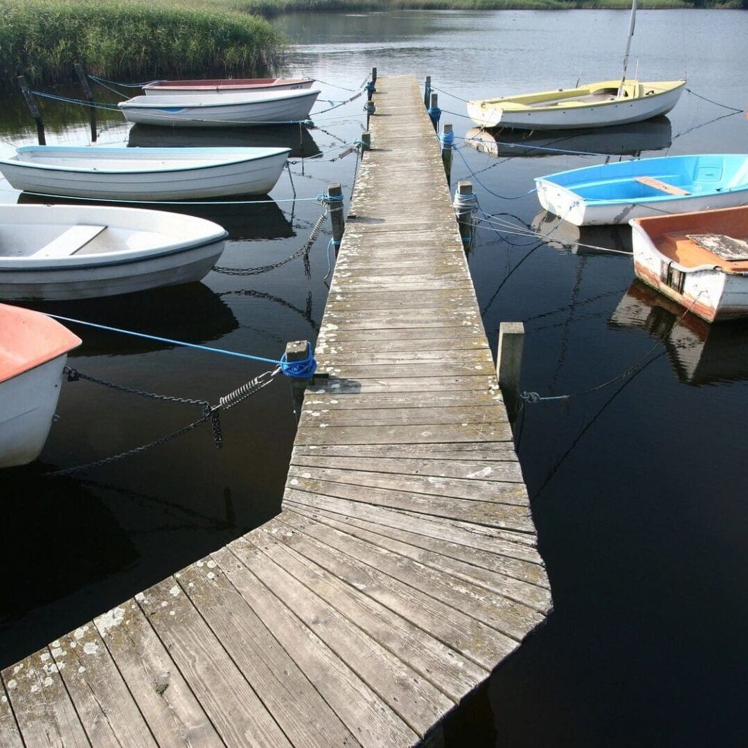 A dock with many small boats in the water.